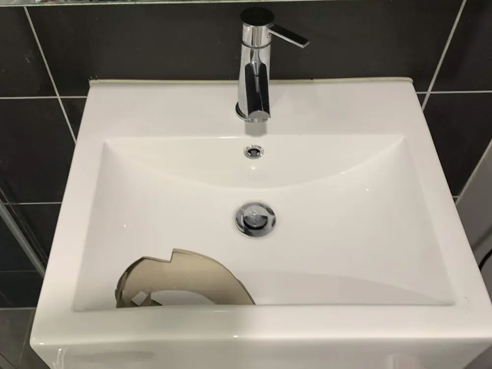 Before — a badly cracked bathroom basin replaced with a new basin and mixer tap