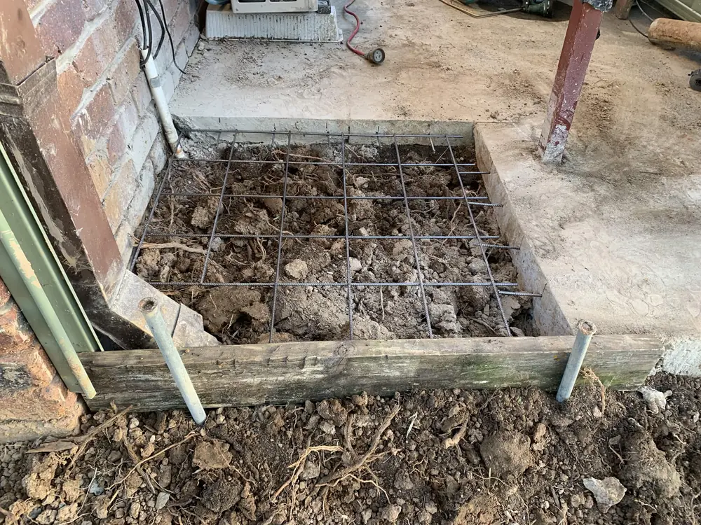 Before — reo mesh laid over a drain repair, then the finished concrete poured back level with the existing slab