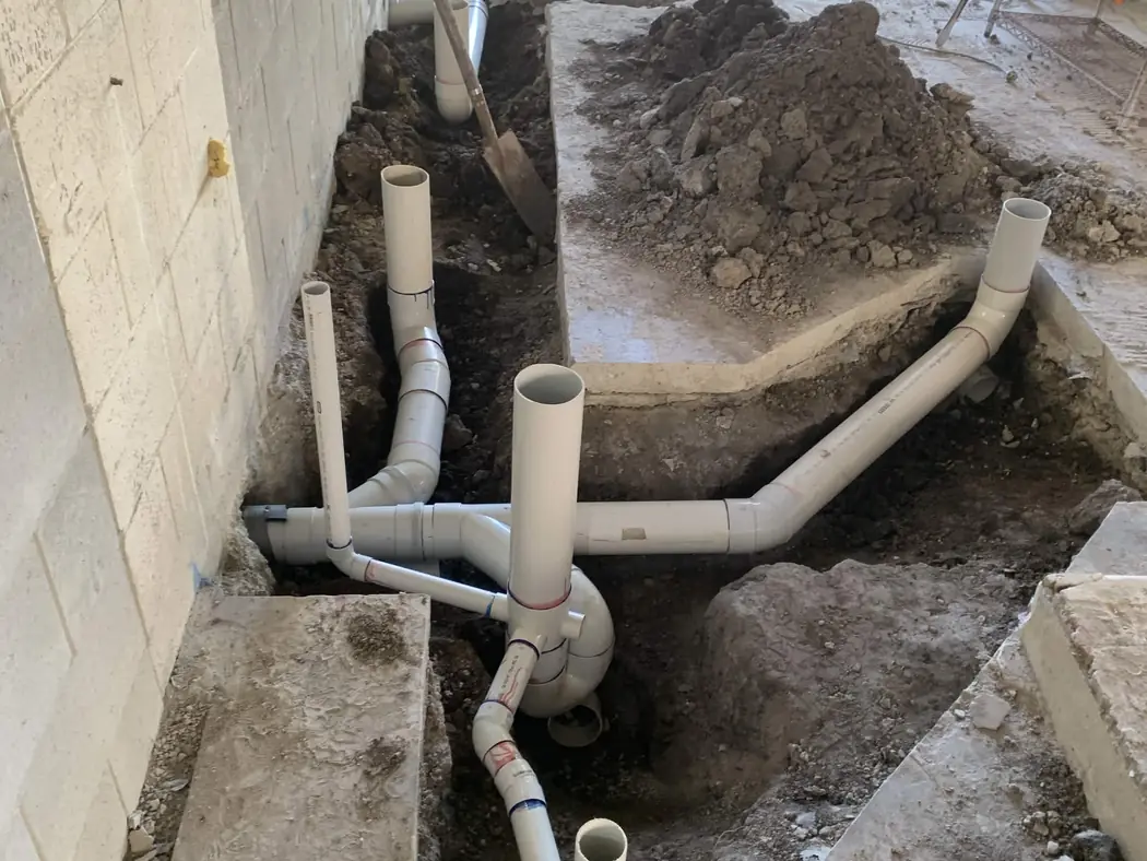 sewer and waste drainage rough-in pipework laid in trenches before the slab goes down